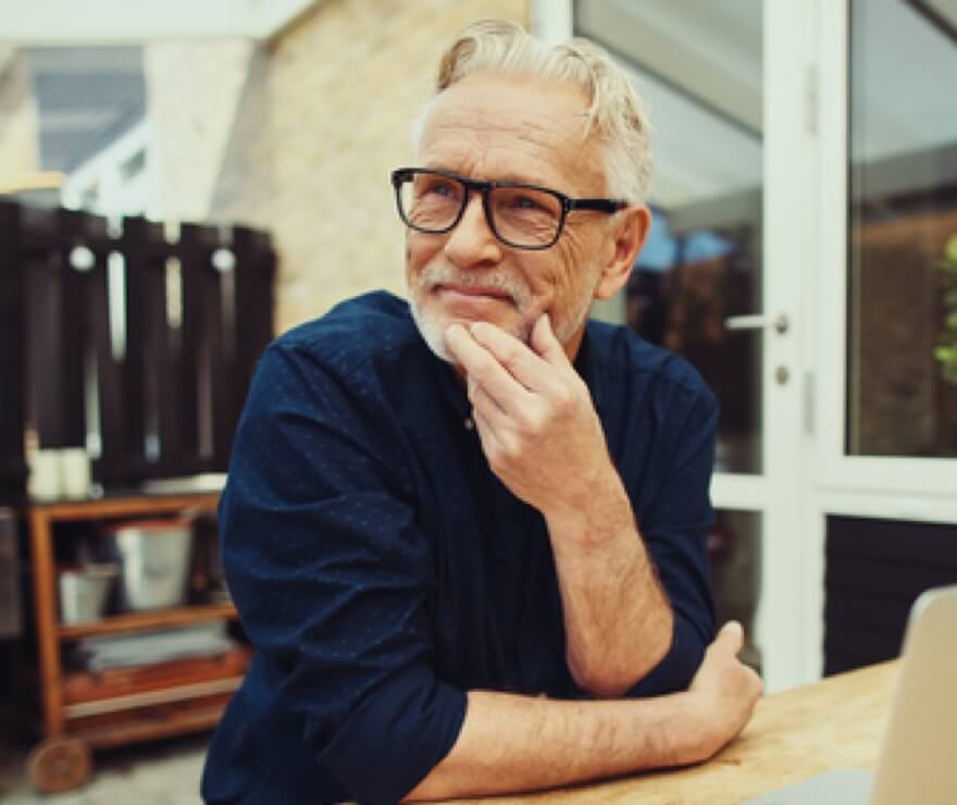 A man sits at a table and looks at something in the distance