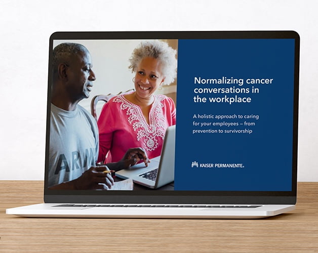 Laptop with an image of two people having a friendly conversation and text 'Normalizing cancer conversations in the workplace