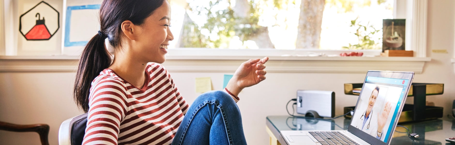 Woman laughing during a video call with her doctor